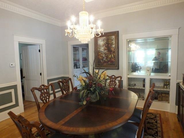 dining room featuring a notable chandelier, crown molding, and wood-type flooring