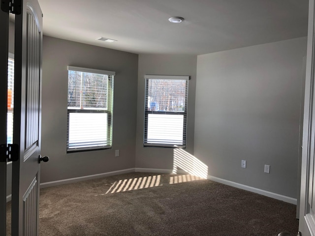 unfurnished room with dark carpet