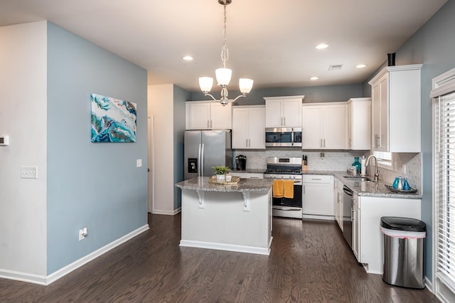 kitchen with decorative light fixtures, a kitchen island, dark hardwood / wood-style floors, and stainless steel appliances