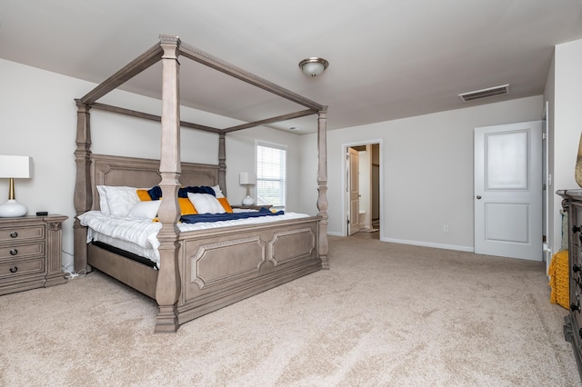 bedroom with light carpet and ensuite bath