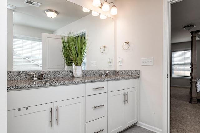 bathroom with double sink vanity and a wealth of natural light