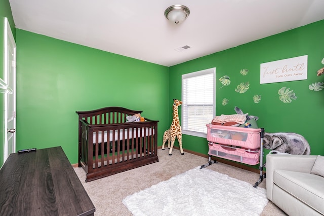 bedroom with light carpet and a nursery area