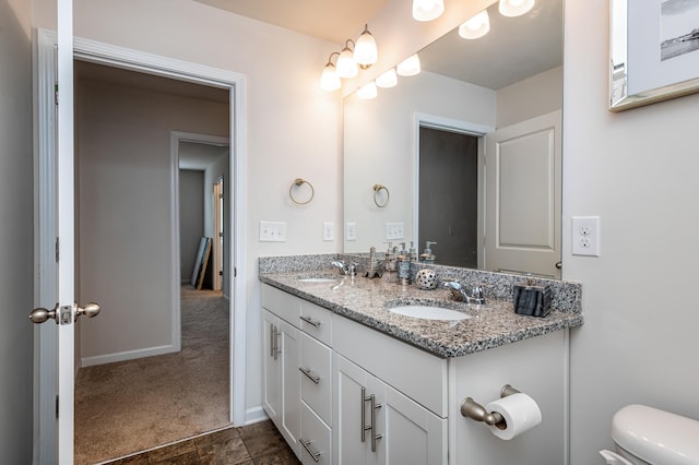 bathroom featuring toilet, double sink vanity, and tile flooring