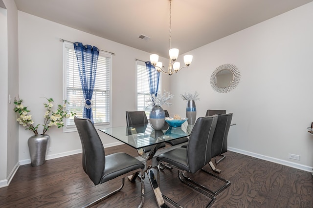 dining space featuring dark hardwood / wood-style floors and a chandelier