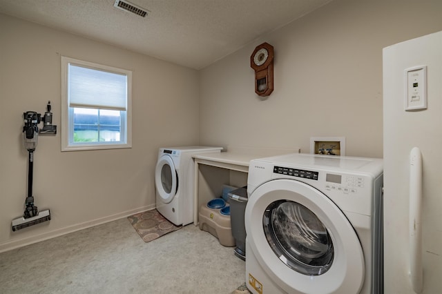 clothes washing area featuring washer hookup, washing machine and dryer, a textured ceiling, and light colored carpet