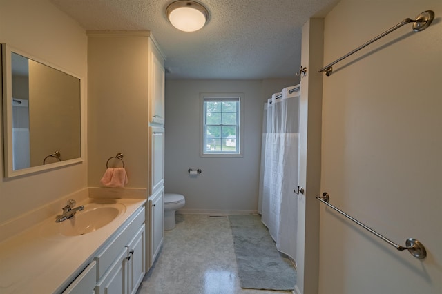 bathroom featuring toilet, oversized vanity, and a textured ceiling