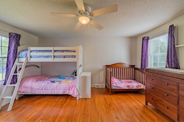 bedroom featuring a textured ceiling, ceiling fan, and light hardwood / wood-style flooring