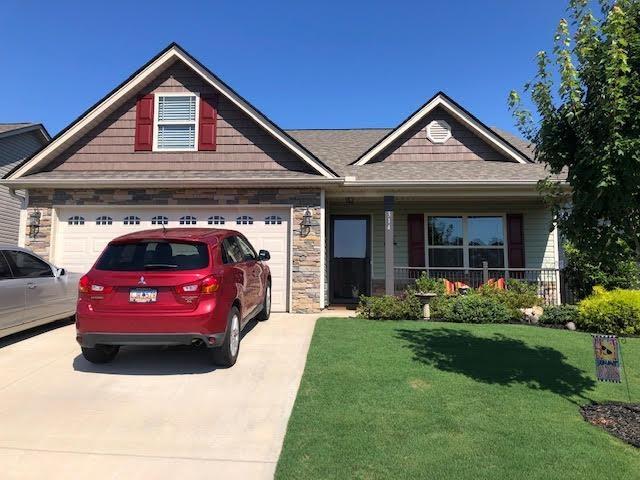 view of front of home with a porch, a front lawn, and a garage