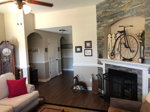 living room with dark hardwood / wood-style flooring and ceiling fan