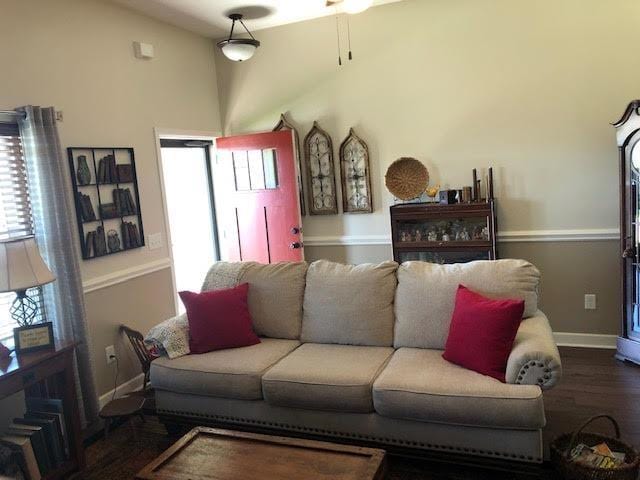 living room featuring a wealth of natural light, dark wood-type flooring, and a high ceiling