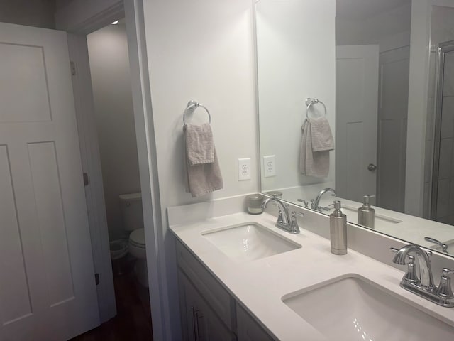 bathroom featuring double sink, oversized vanity, and toilet