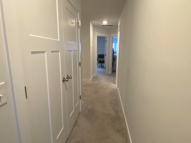 hallway featuring light colored carpet