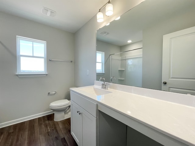 bathroom with hardwood / wood-style flooring, vanity, an enclosed shower, and toilet