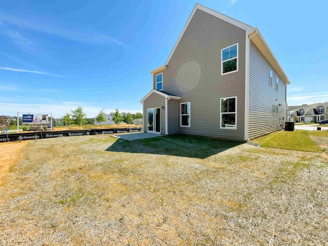 back of house with a yard and central air condition unit