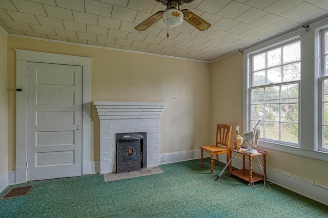 interior space with a fireplace, carpet flooring, and ceiling fan