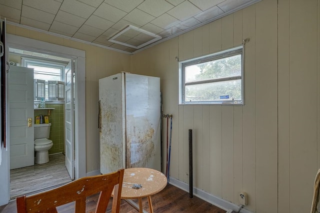 interior space with tile walls, toilet, and wood-type flooring