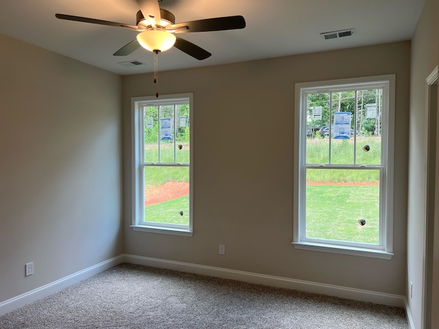 spare room featuring plenty of natural light, carpet, and ceiling fan