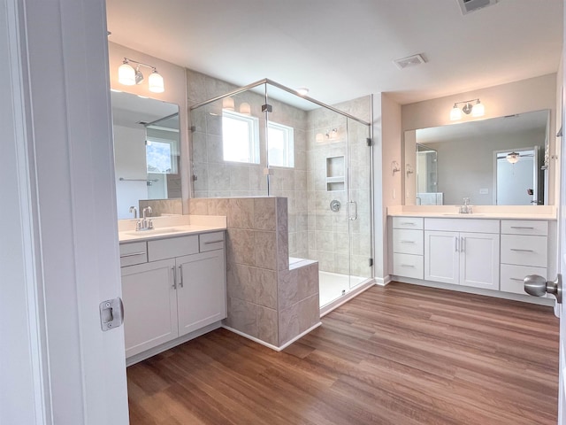 bathroom featuring hardwood / wood-style flooring, vanity, a shower with door, and ceiling fan