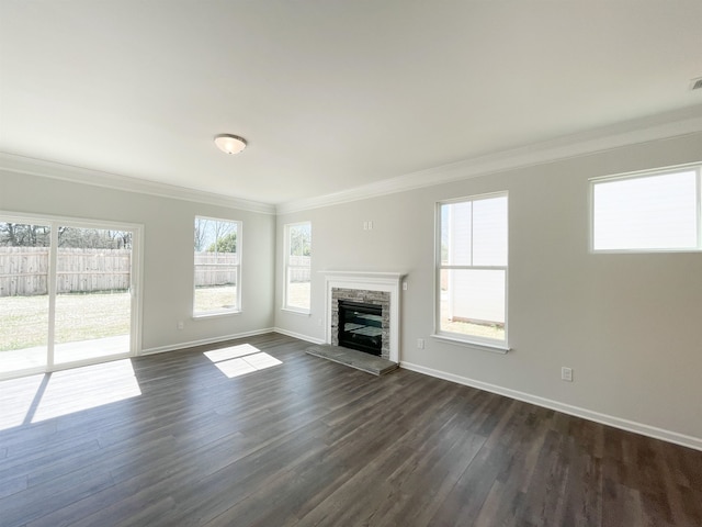 unfurnished living room with dark hardwood / wood-style flooring, ornamental molding, and a stone fireplace