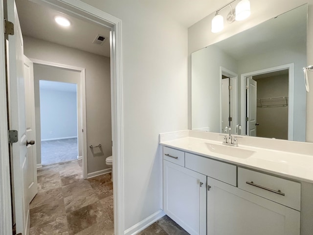 bathroom with toilet, tile floors, and vanity