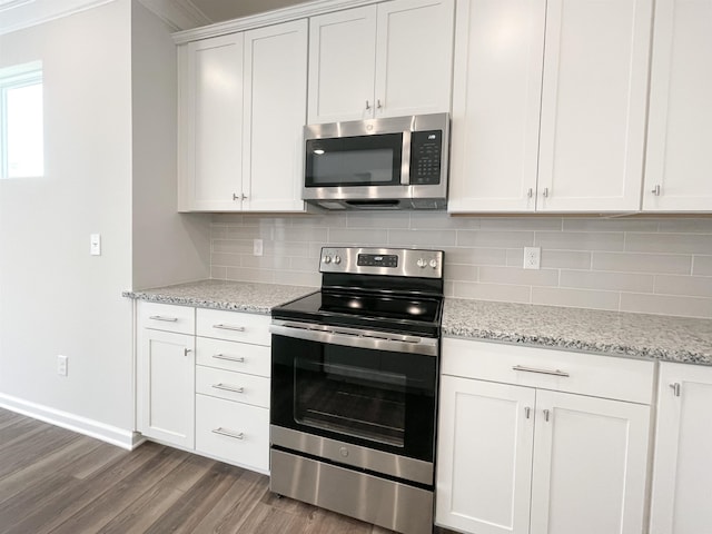 kitchen featuring ornamental molding, white cabinets, backsplash, stainless steel appliances, and hardwood / wood-style flooring