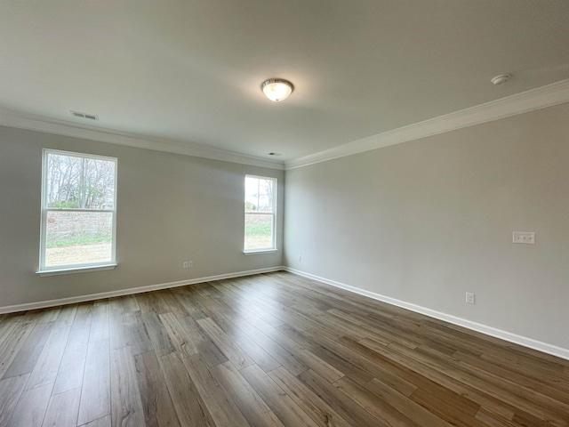 spare room featuring crown molding and dark wood-type flooring