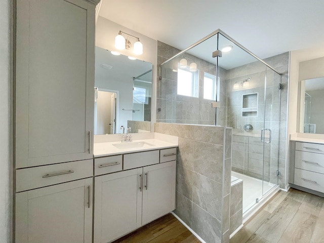 bathroom featuring an enclosed shower, vanity, and hardwood / wood-style flooring