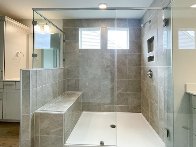 bathroom featuring an enclosed shower, vanity, and wood-type flooring