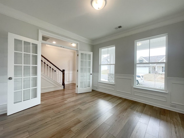 spare room with hardwood / wood-style floors, crown molding, and french doors