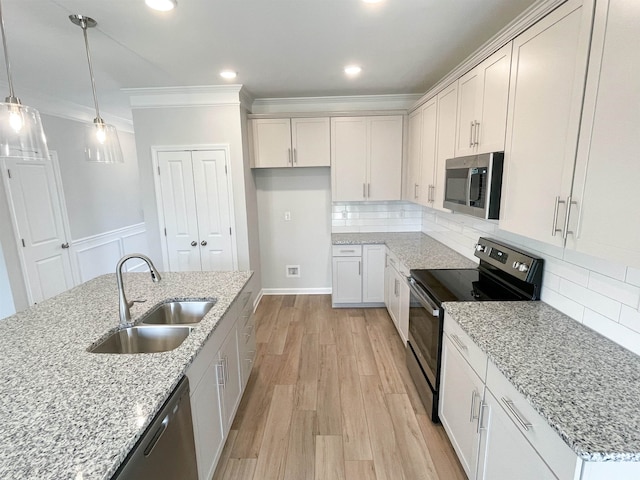 kitchen featuring crown molding, stainless steel appliances, backsplash, and light hardwood / wood-style floors