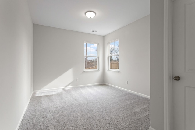 carpeted empty room featuring visible vents and baseboards