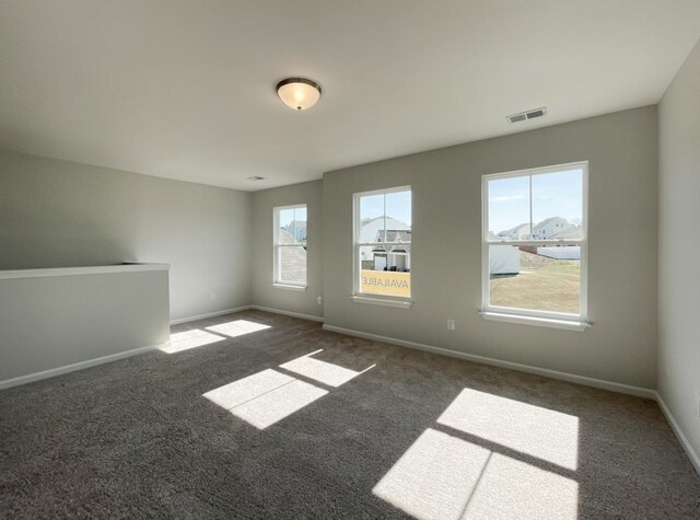 unfurnished room with dark colored carpet