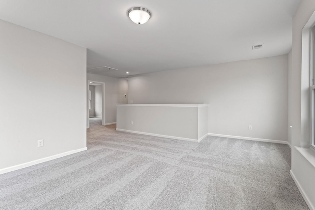 spare room featuring visible vents, carpet flooring, and baseboards