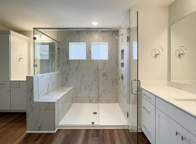 bathroom featuring hardwood / wood-style flooring, vanity, and a shower with shower door