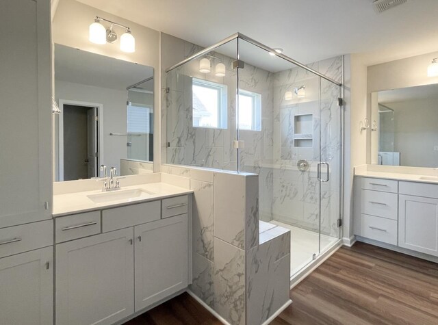 bathroom featuring vanity, hardwood / wood-style flooring, and a shower with shower door