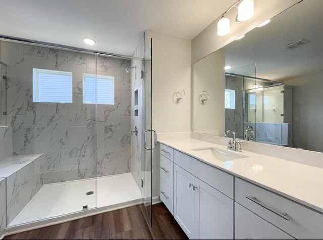 bathroom with wood-type flooring, vanity, and walk in shower