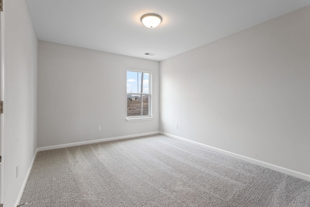 spare room with visible vents, carpet, and baseboards