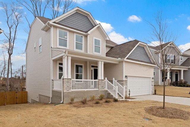 craftsman inspired home featuring fence, driveway, a porch, an attached garage, and stone siding