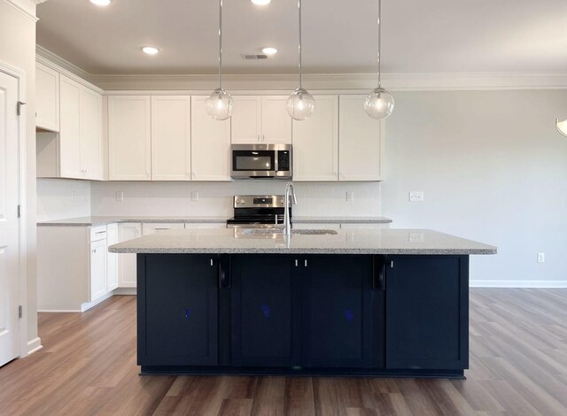 kitchen featuring stainless steel appliances, sink, a center island with sink, and white cabinets