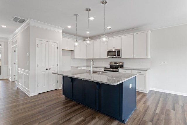 kitchen with crown molding, light stone countertops, stainless steel appliances, white cabinetry, and a sink