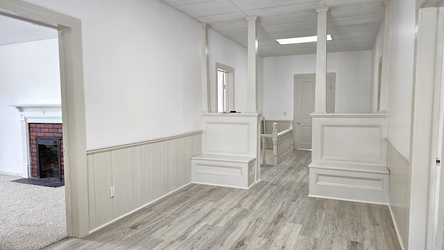 walk in closet featuring light colored carpet and a fireplace