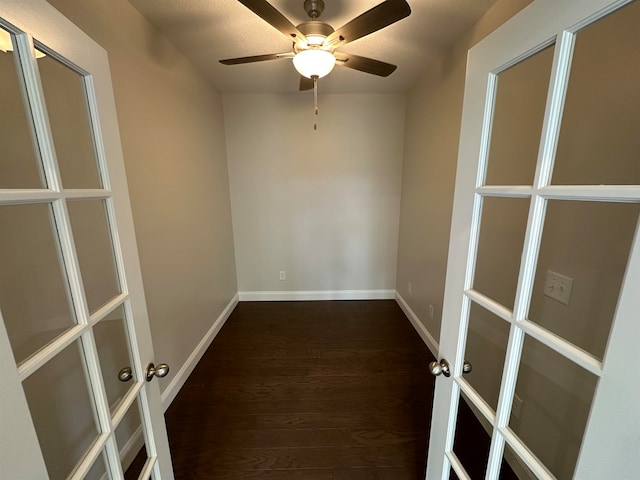 empty room with dark hardwood / wood-style floors, ceiling fan, and french doors