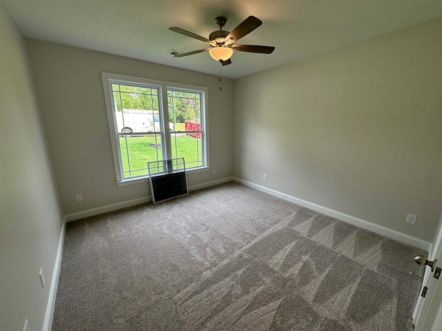 carpeted empty room featuring a healthy amount of sunlight and ceiling fan