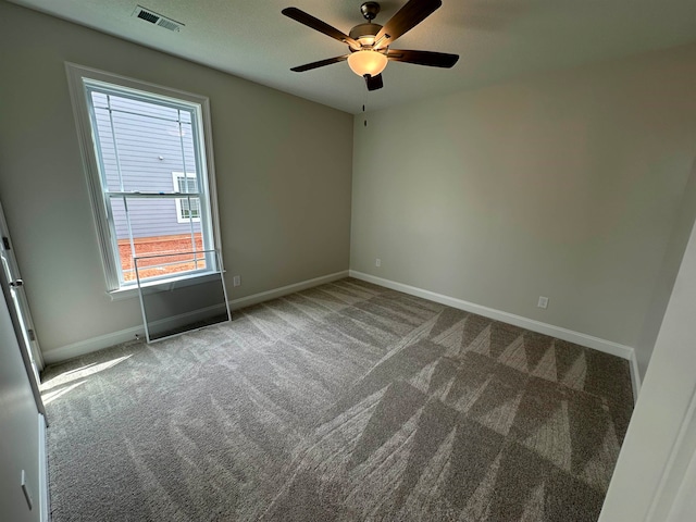 carpeted spare room featuring ceiling fan