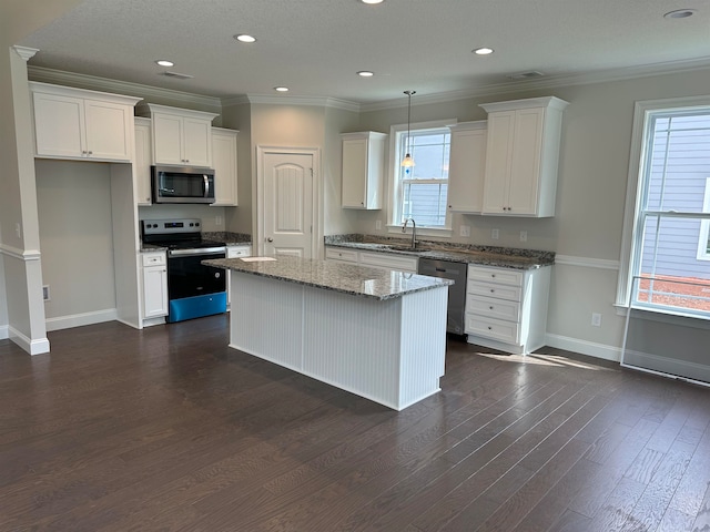 kitchen featuring white cabinets, dark hardwood / wood-style floors, appliances with stainless steel finishes, and pendant lighting