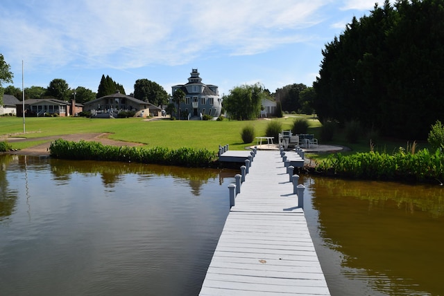 dock area with a water view and a yard