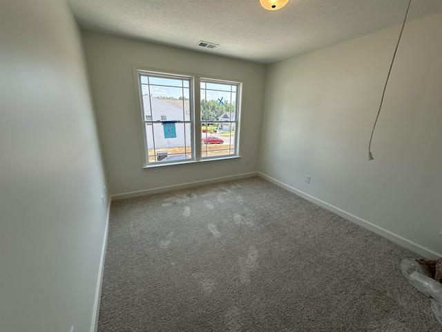 unfurnished room with baseboards, a textured ceiling, visible vents, and carpet flooring