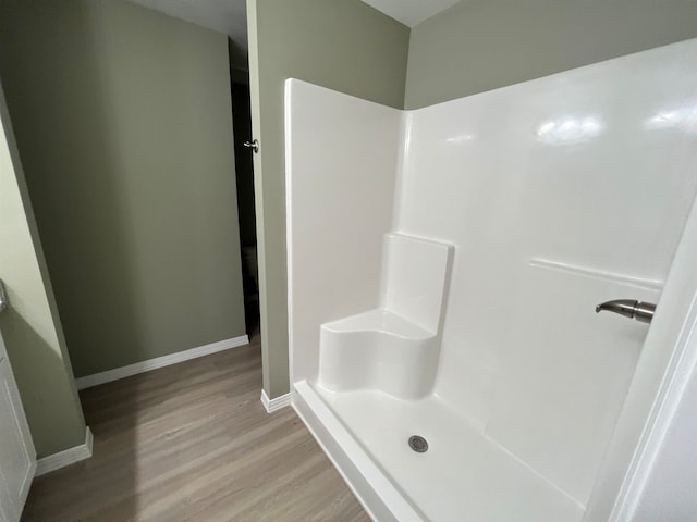 bathroom with hardwood / wood-style floors and a shower