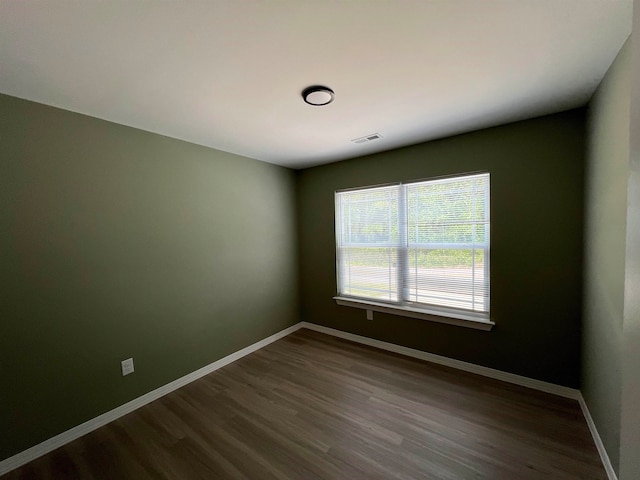 unfurnished room with dark wood-type flooring