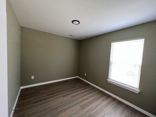 empty room with dark hardwood / wood-style flooring